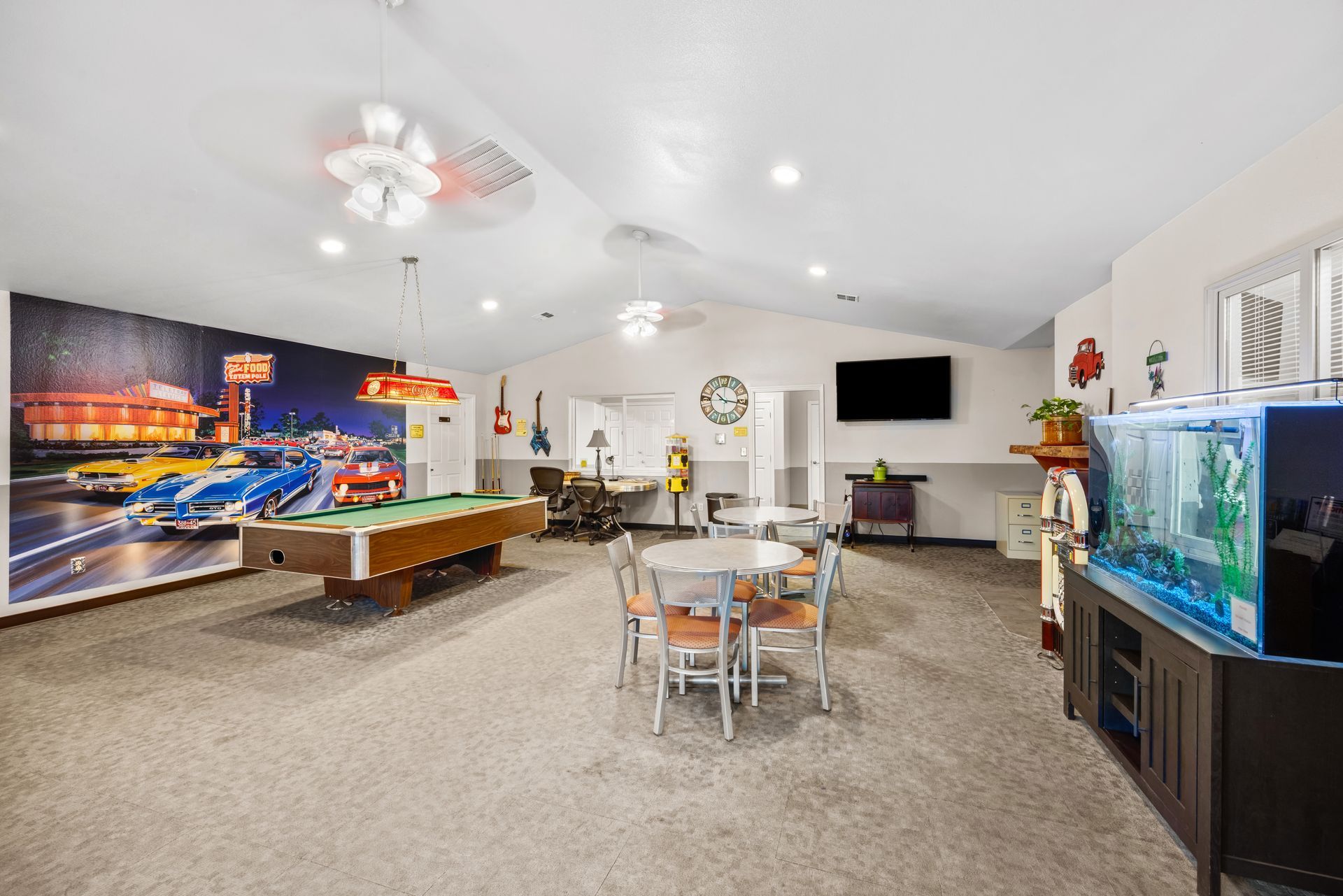 Spacious game room at the Boise Meridian KOA with pool table, dining table, fireplace, TV, and large aquarium.