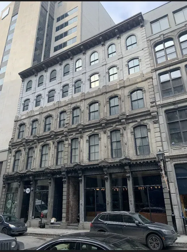 A building with a lot of windows and a car parked in front of it.