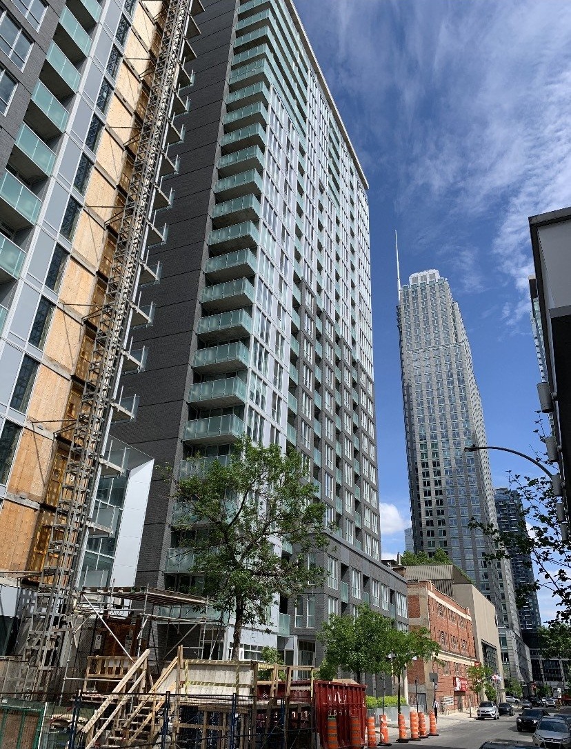 A tall building is under construction in the middle of a city.