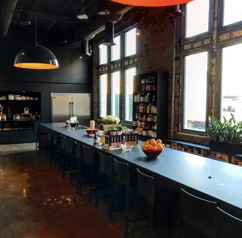 A long table with a bowl of oranges on it