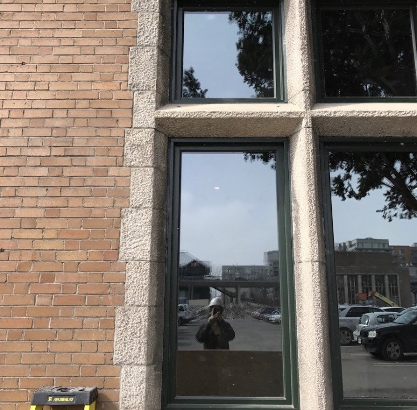 A window with a reflection of a person taking a picture