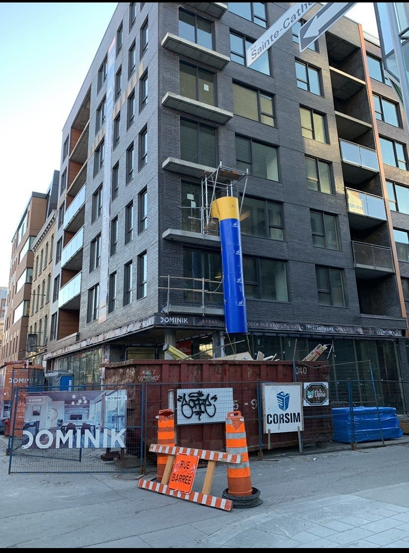 A large brick building is being built in a city.