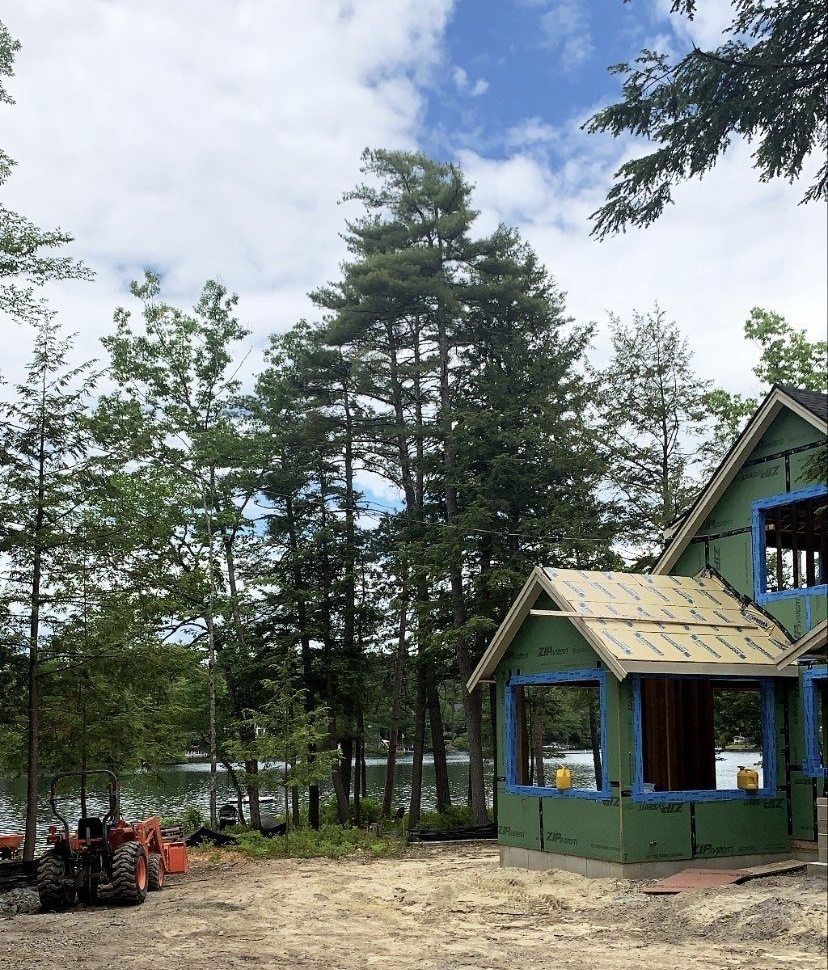 A tractor is parked in front of a house under construction