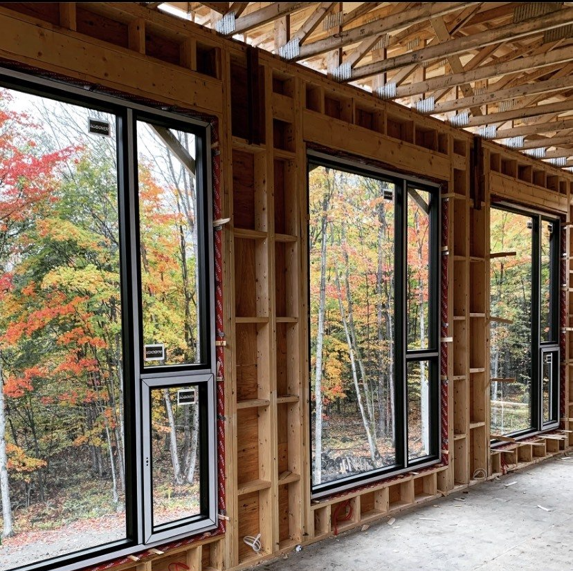 A room with a lot of windows and trees in the background