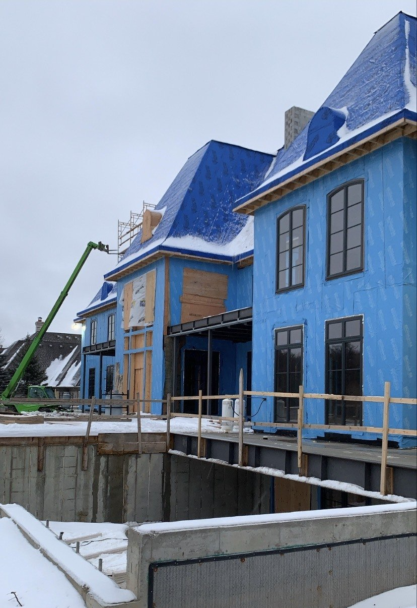 A large blue house is being built in the snow