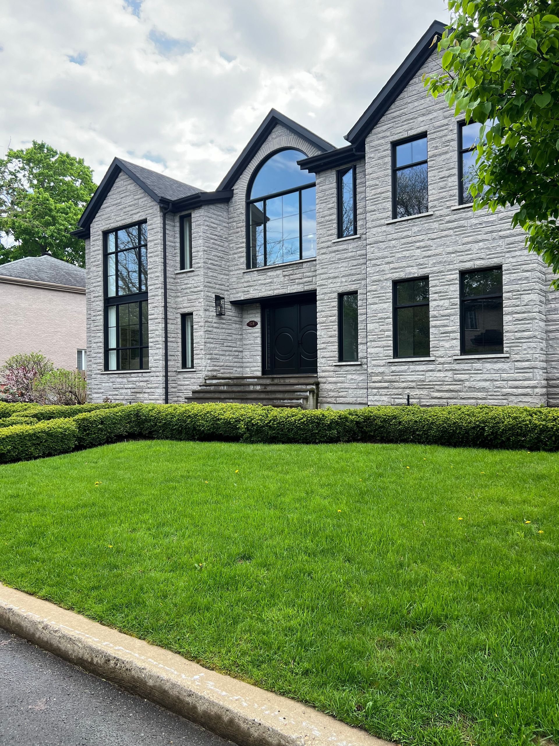 A large brick house with a lush green lawn in front of it.