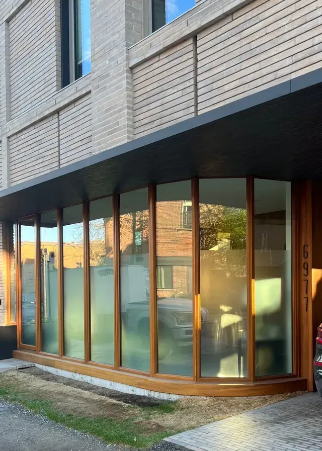 Un grand bâtiment avec beaucoup de fenêtres et une porte en bois.