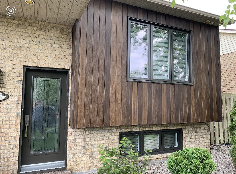 A brick house with a wooden siding and a large window.