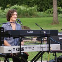 A man is playing a keyboard and singing into a microphone.