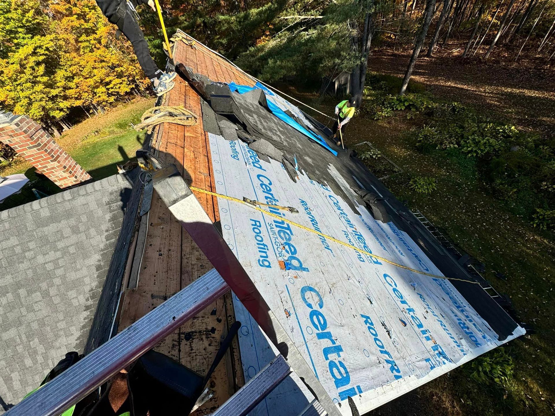 A man is working on the roof of a house.