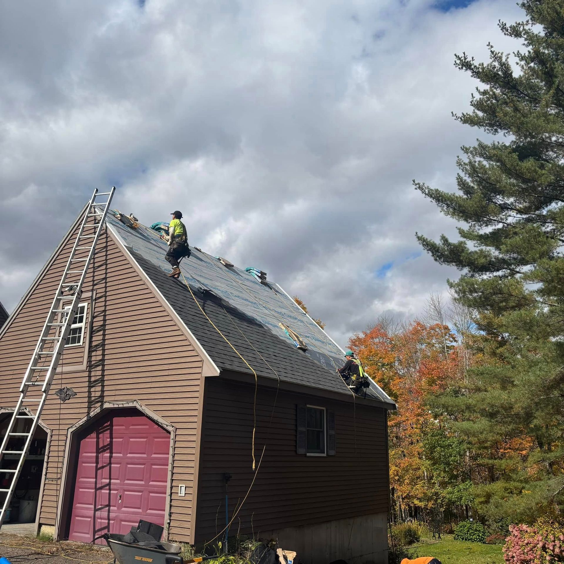 Two men are working on the roof of a house