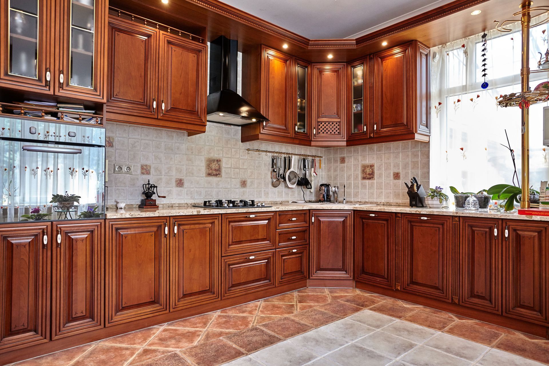 Spacious kitchen with dark wood cabinets, tiled backsplash, and a sunlit window above the sink.