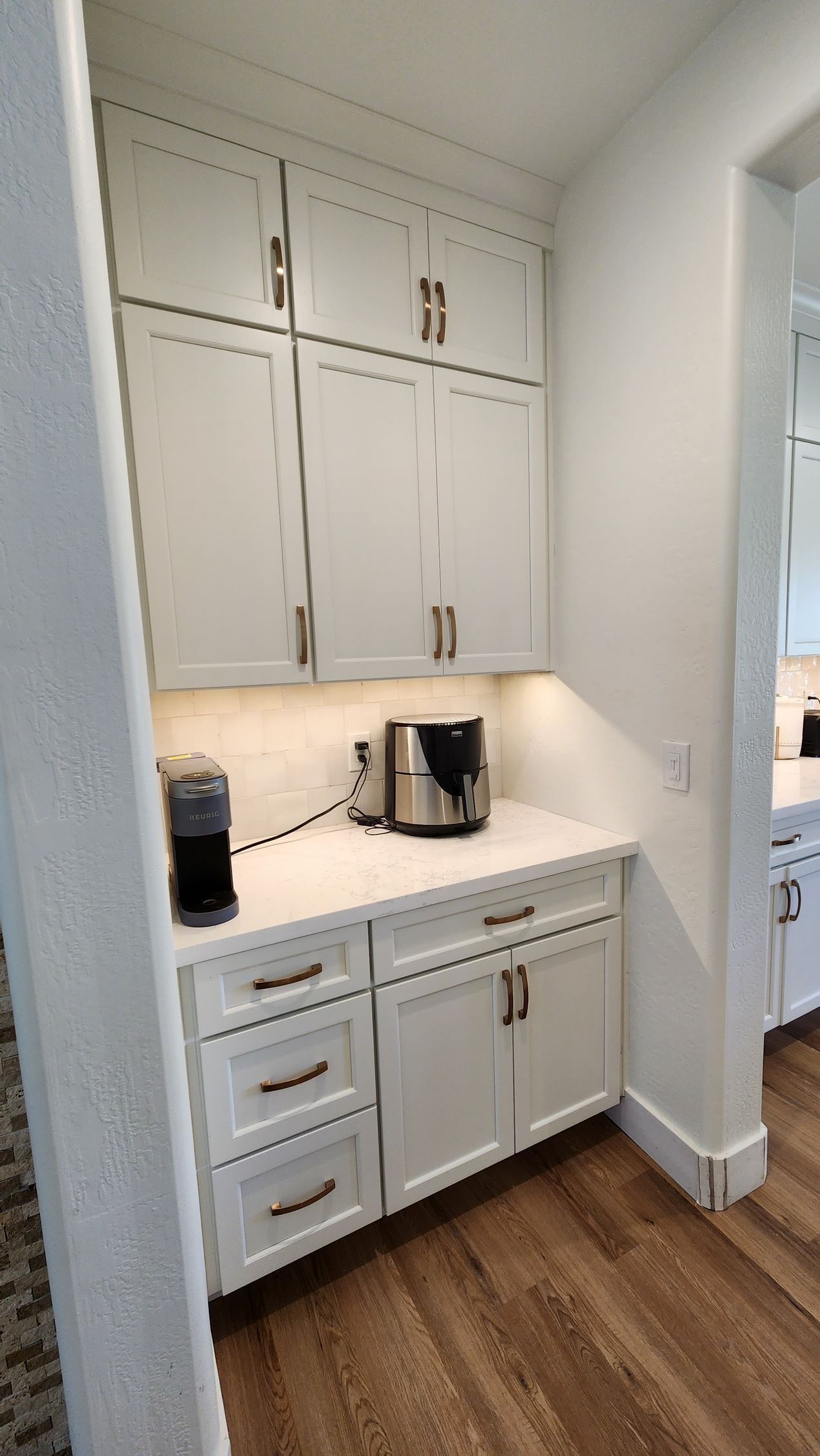 White built-in kitchen cabinetry with countertop, drawers, and small appliances in a narrow alcove.
