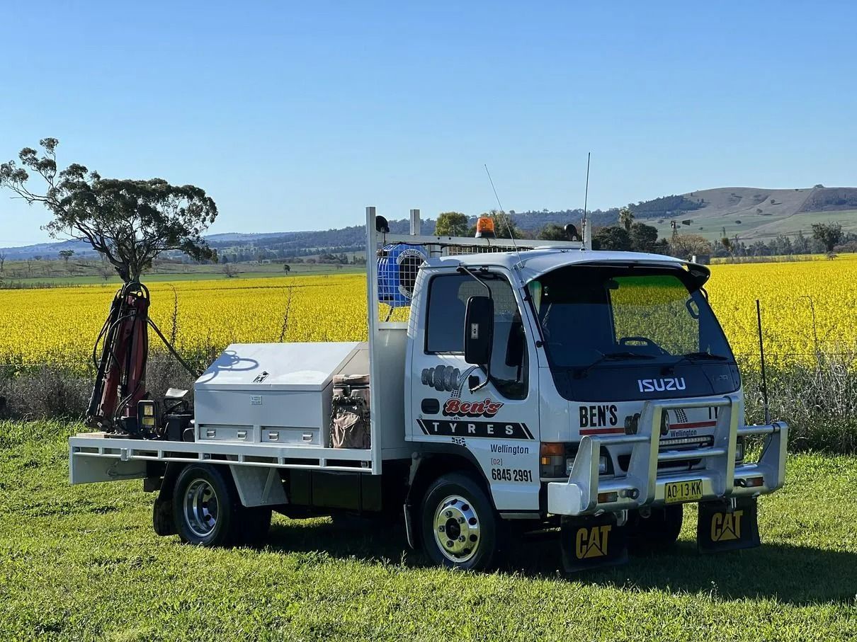 White Isuzu Truck With a Flatbed — Ben's Tyres in Wellington, NSW