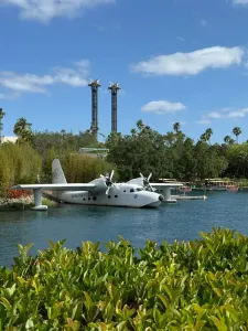 Seaplane floating on a lagoon with palm trees and a blue sky in the background