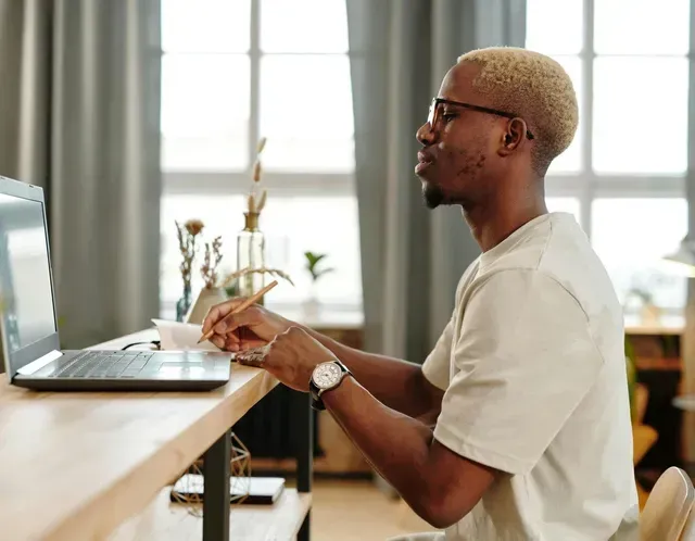 Person typing on a laptop at a desk in a bright office