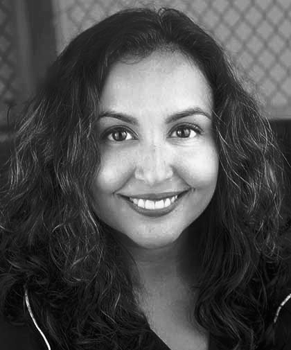 Smiling woman with curly dark hair in black-and-white portrait