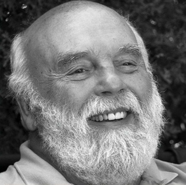 Smiling bearded man in a black-and-white portrait outdoors