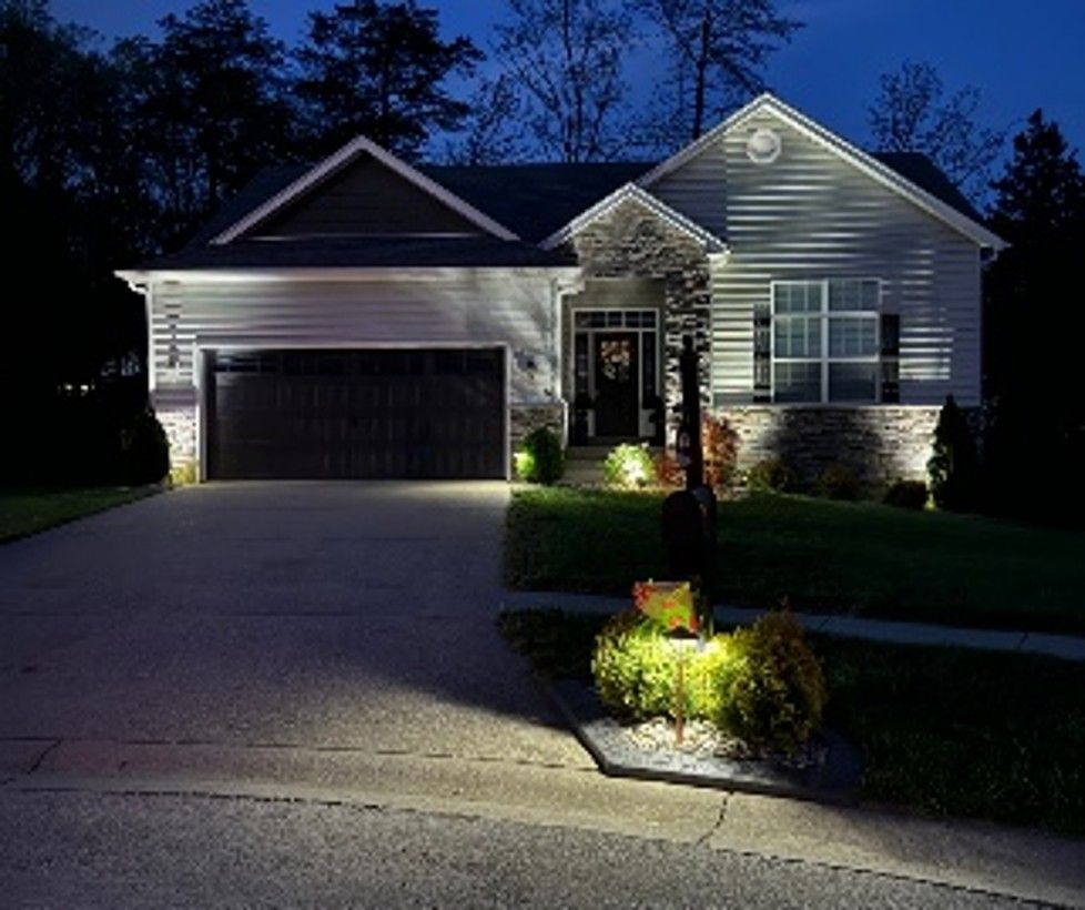 Exterior lighting installation on a home at night.