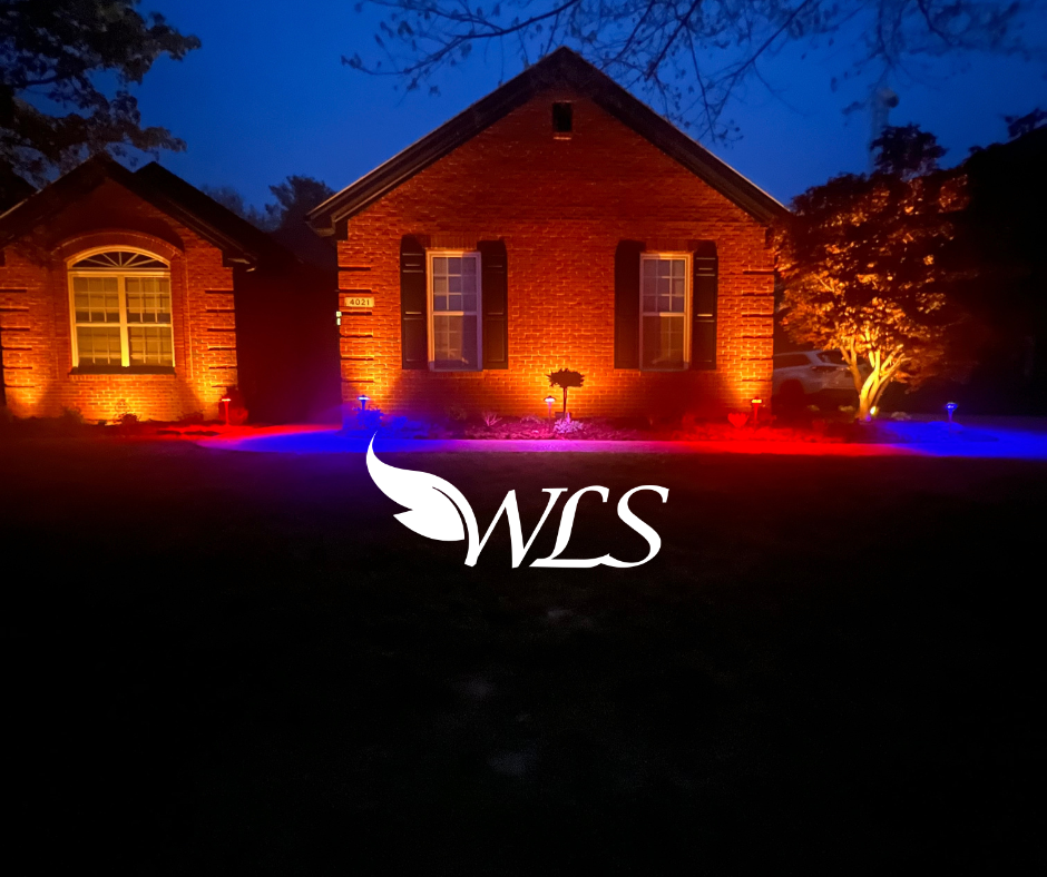 Red brick house illuminated with red and blue outdoor lighting at night. WLS logo overlaid.