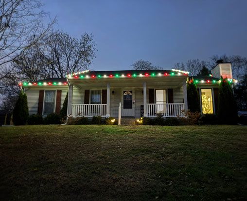 House decorated with Christmas lights, red and green on the roofline, white along the edges, at dusk. House decorated with Christmas lights, red and green on the roofline, white along the edges, at dusk.
