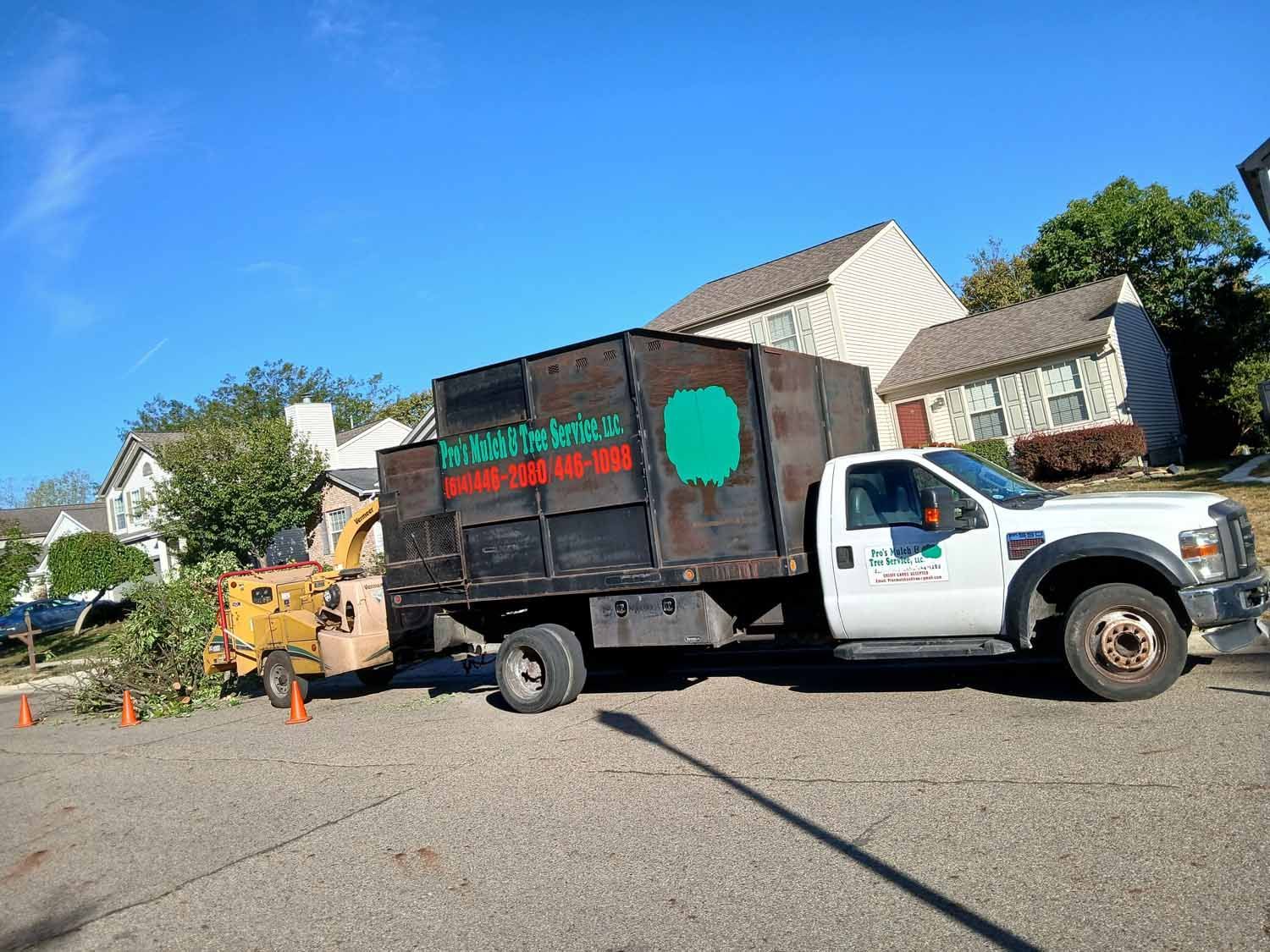 A white truck is parked next to a black truck.