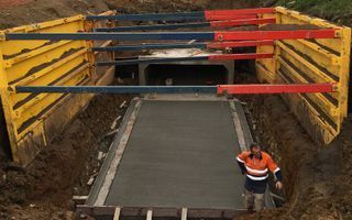A Man Is Standing In A Trench Next To A Concrete Slab – Warrnambool, VIC - McKinnon Quarries & Civil