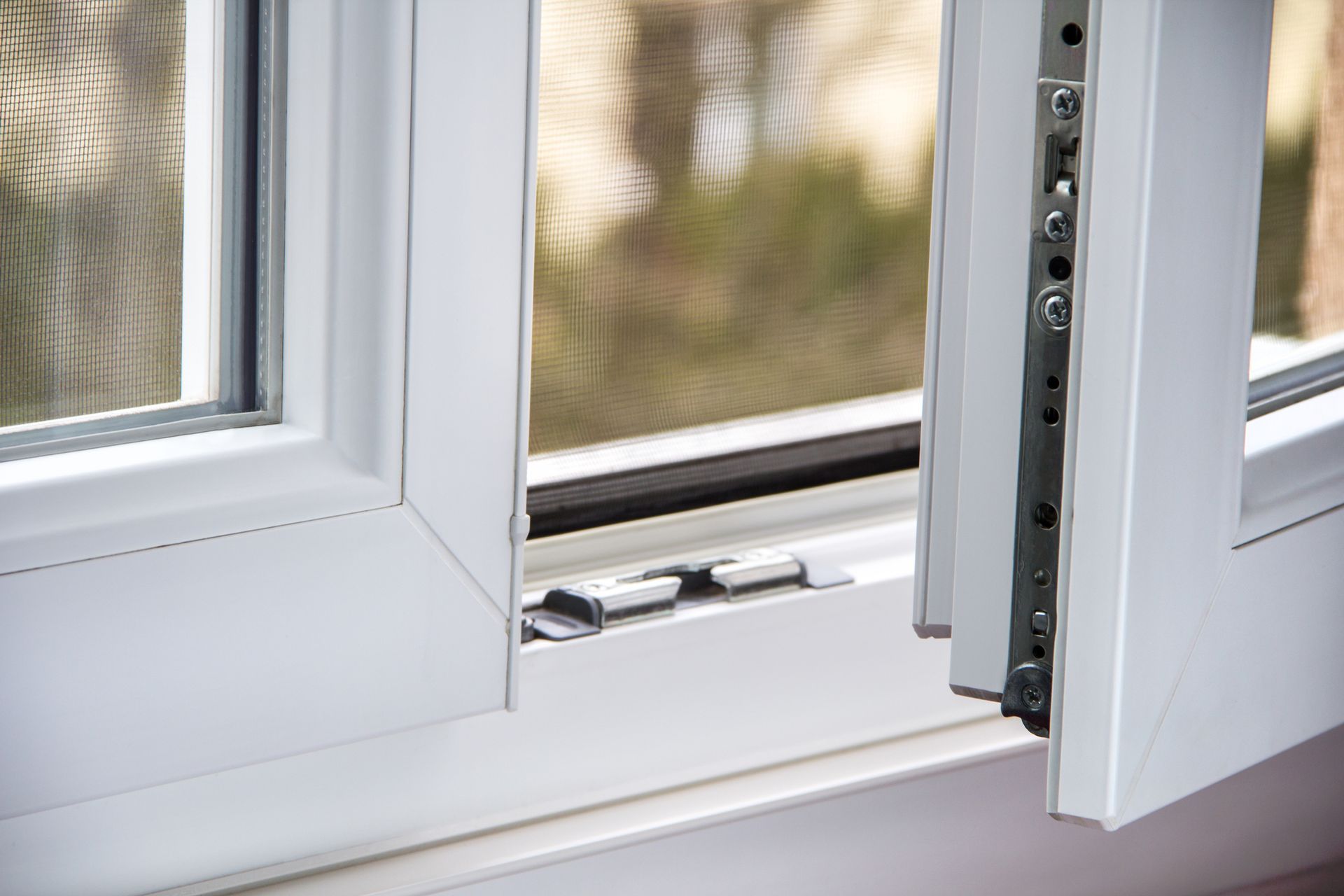 White, casement window; one side slightly ajar, revealing hinges and latch; outdoor view through screen.
