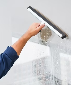 A person is cleaning a window with a squeegee