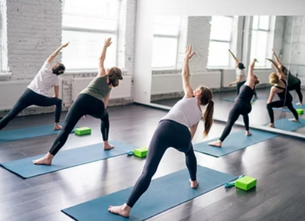 A group of people are practicing yoga in a gym.