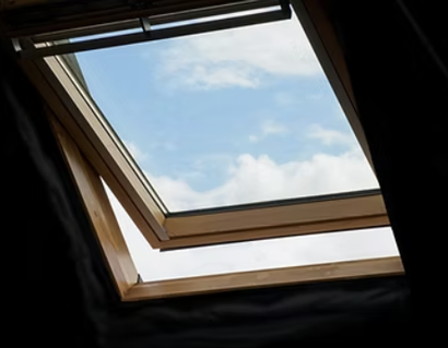Looking through a skylight at a blue sky with clouds