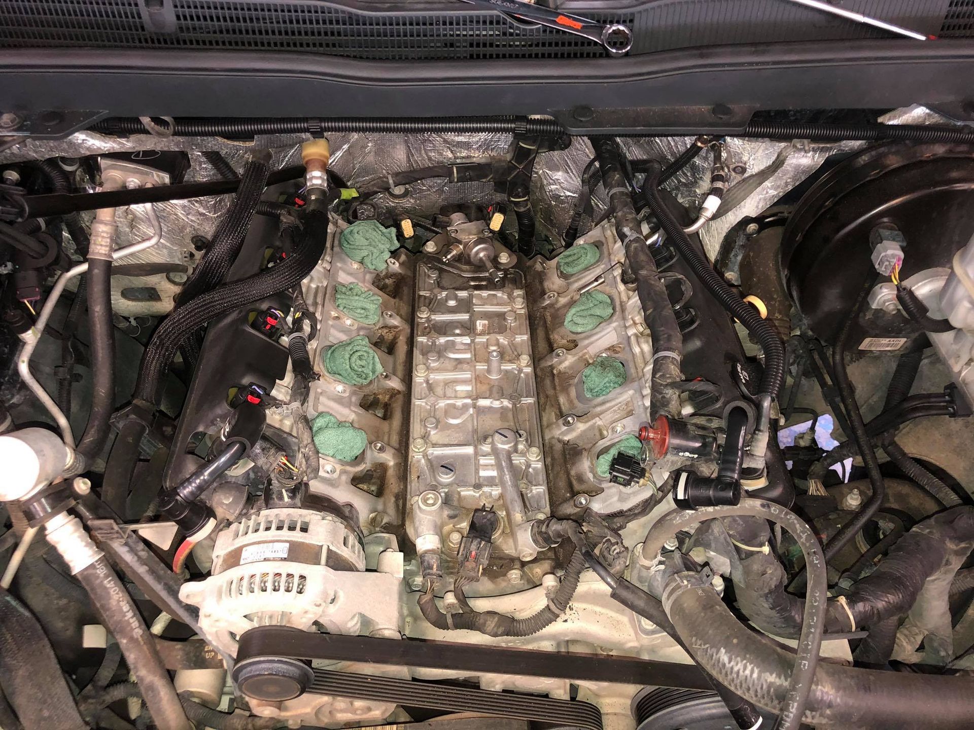 Engine of a vehicle, partially disassembled, showing cylinders, fuel injectors, and wiring.