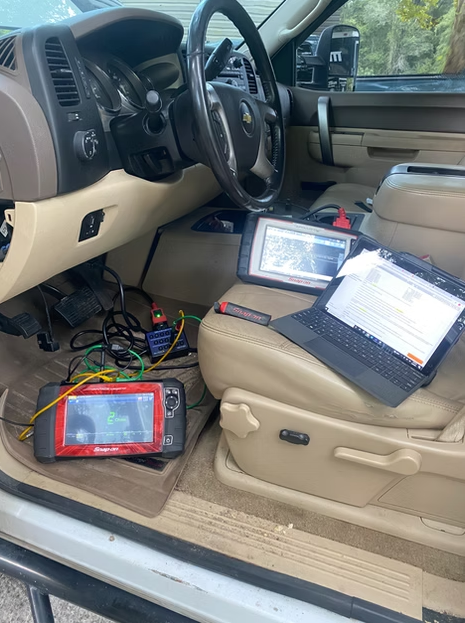 Truck interior with diagnostic tablets and cables on the driver’s seat and floorboard