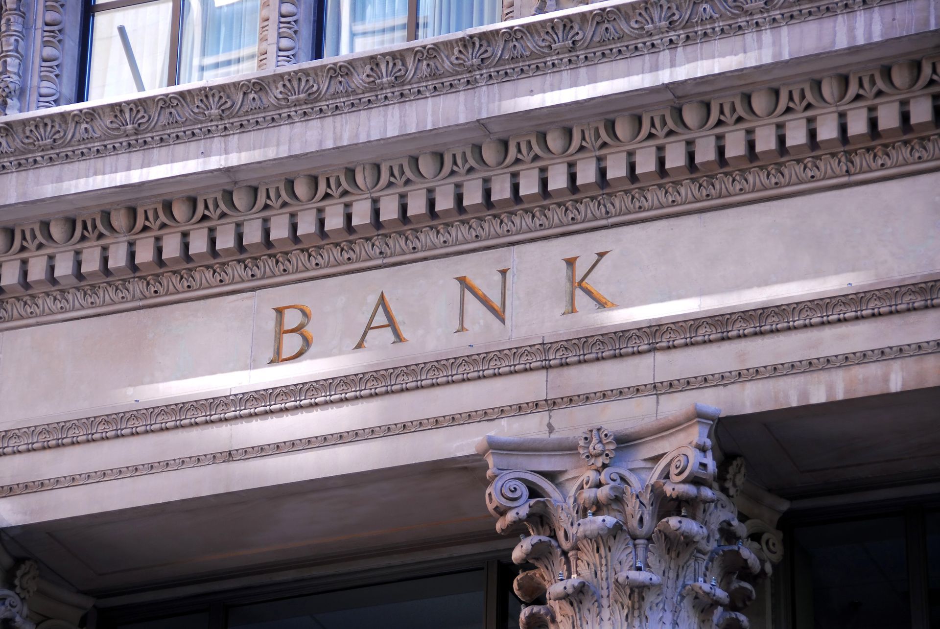 The front of a bank building with the word bank written on it.
