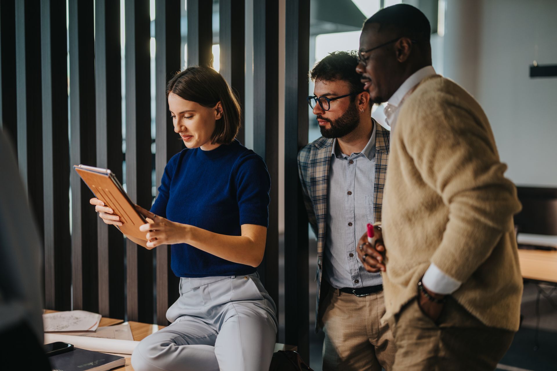 A group of people are looking at a tablet together.
