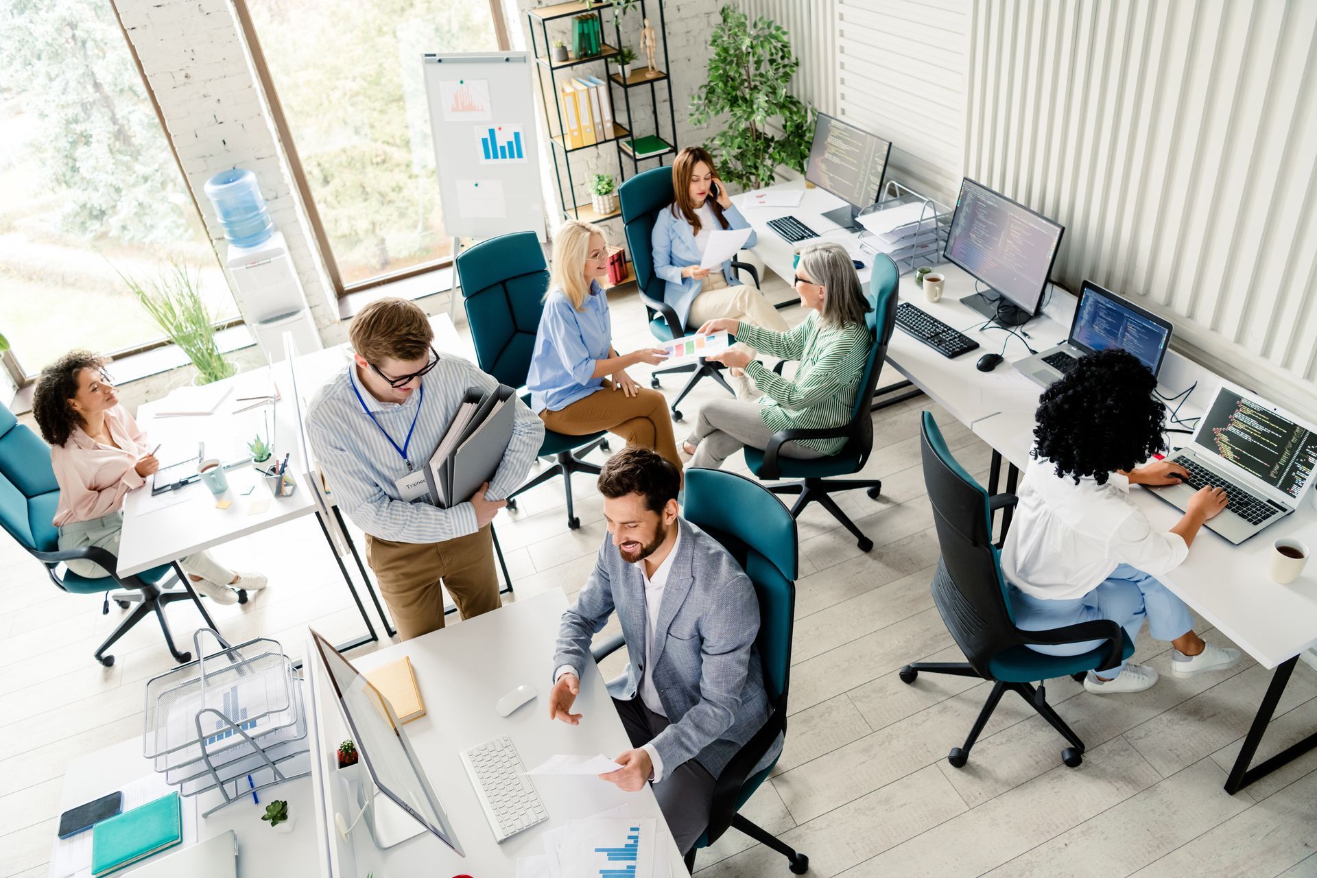 A group of people are sitting at desks in an office.