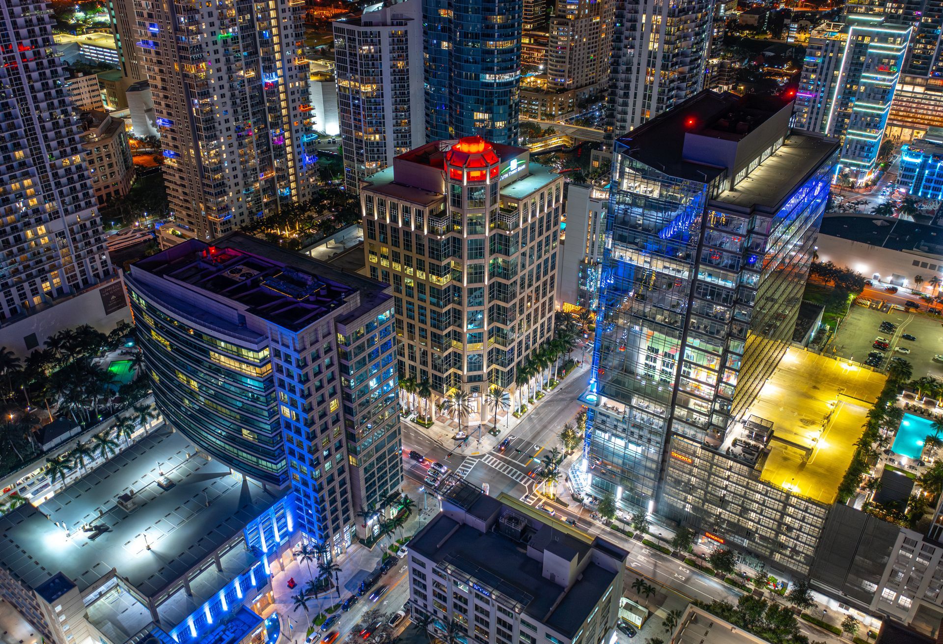Nighttime city skyline with illuminated skyscrapers and glowing streets, viewed from above
