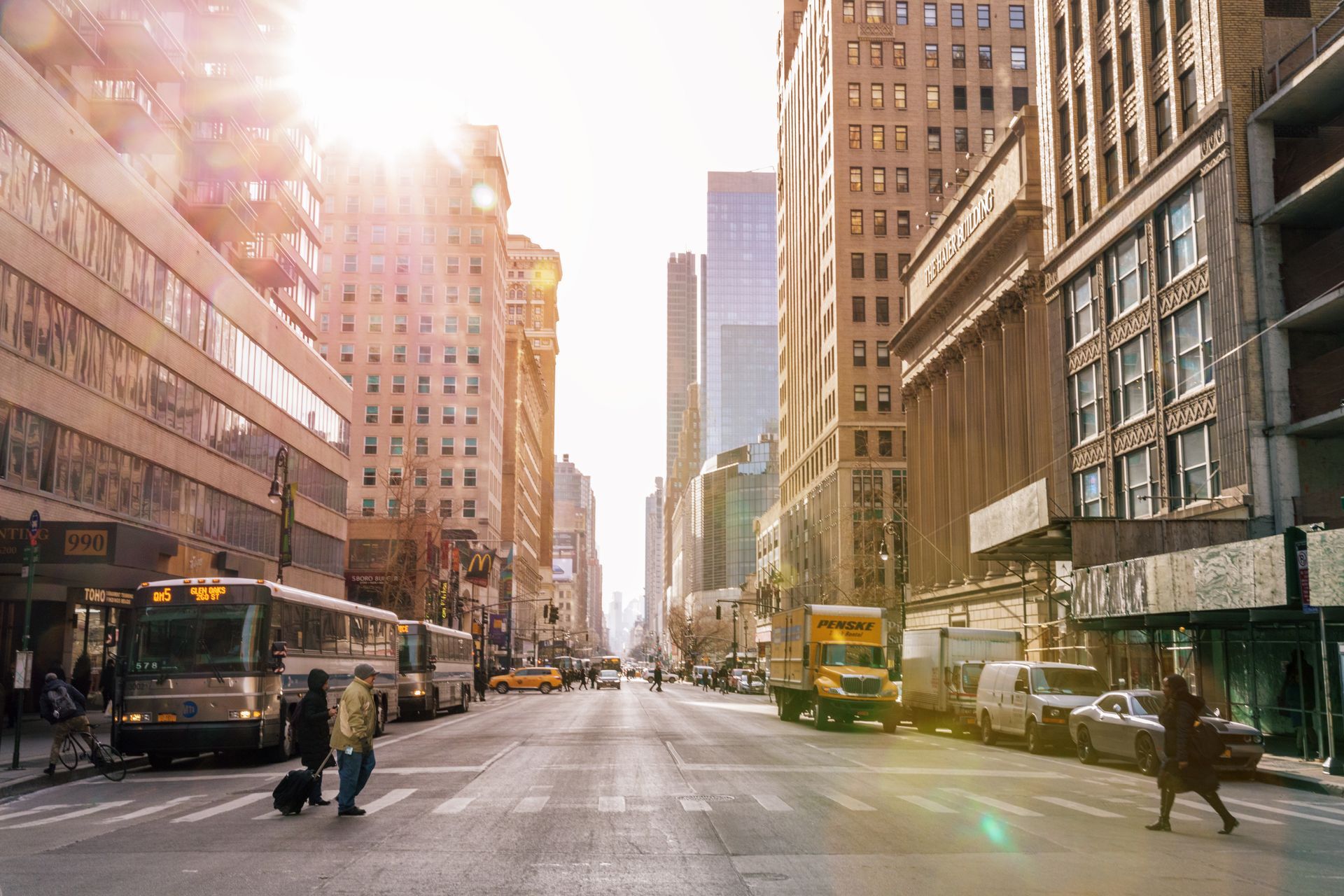 A city street with a lot of buildings and people walking down it.