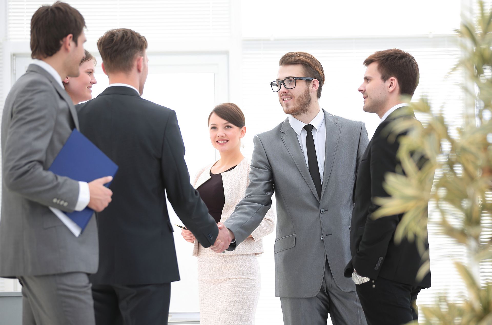 Business professionals shaking hands in a bright office meeting room