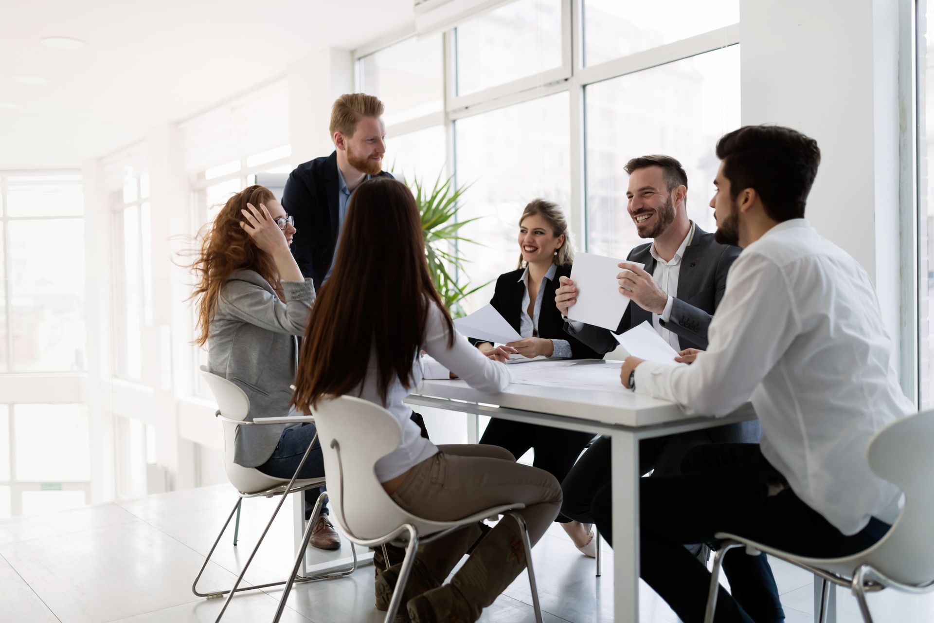 Small business team meeting around a white table in a bright modern office