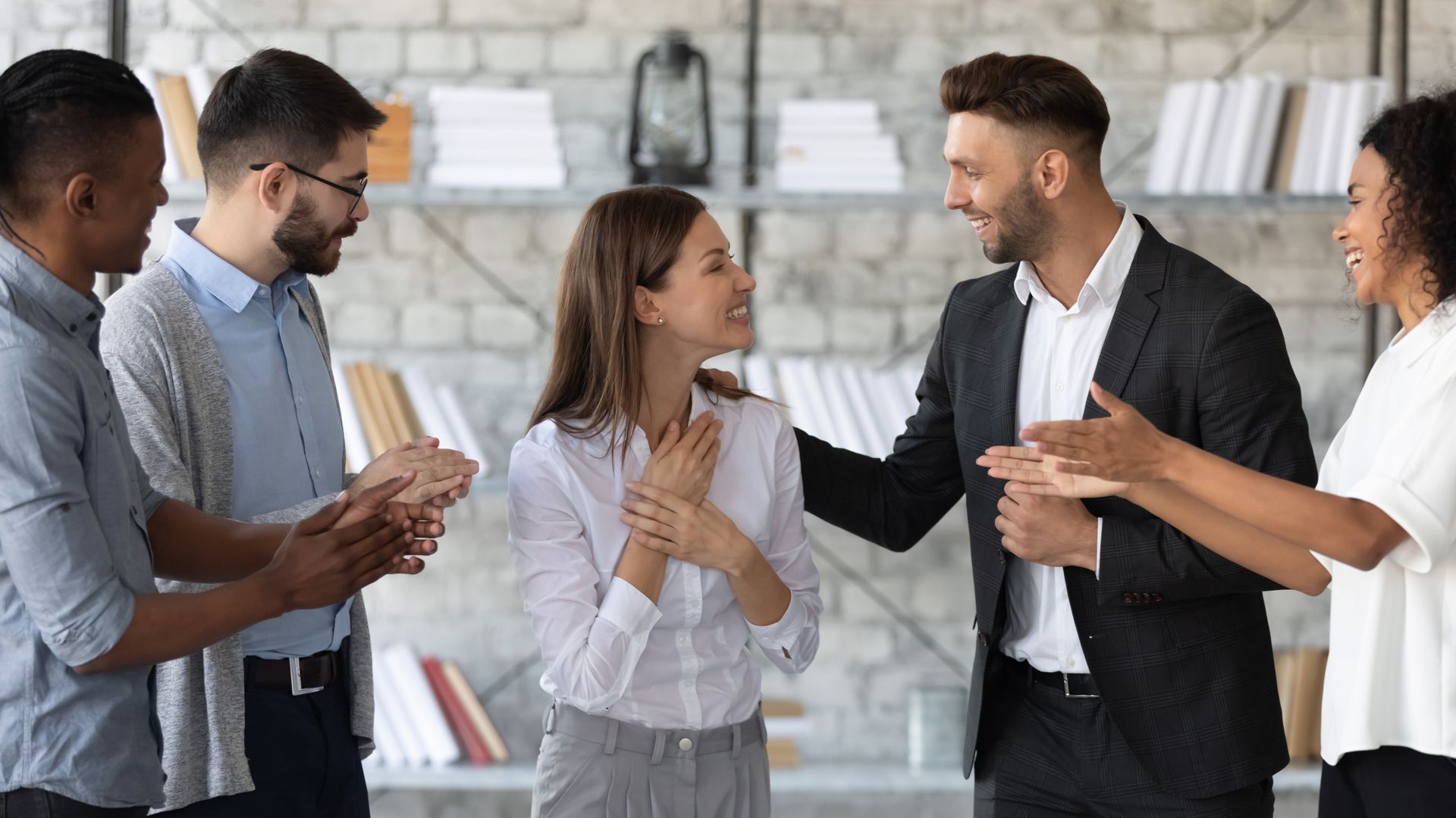 A group of people are clapping in an office.