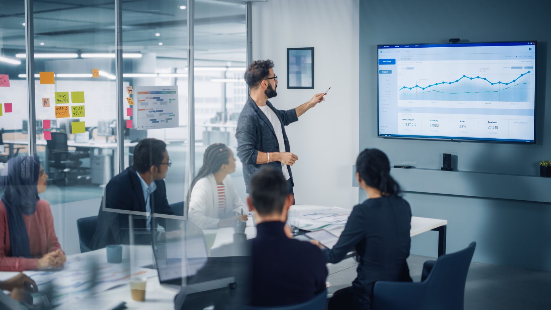 A man is giving a presentation to a group of people in a conference room.
