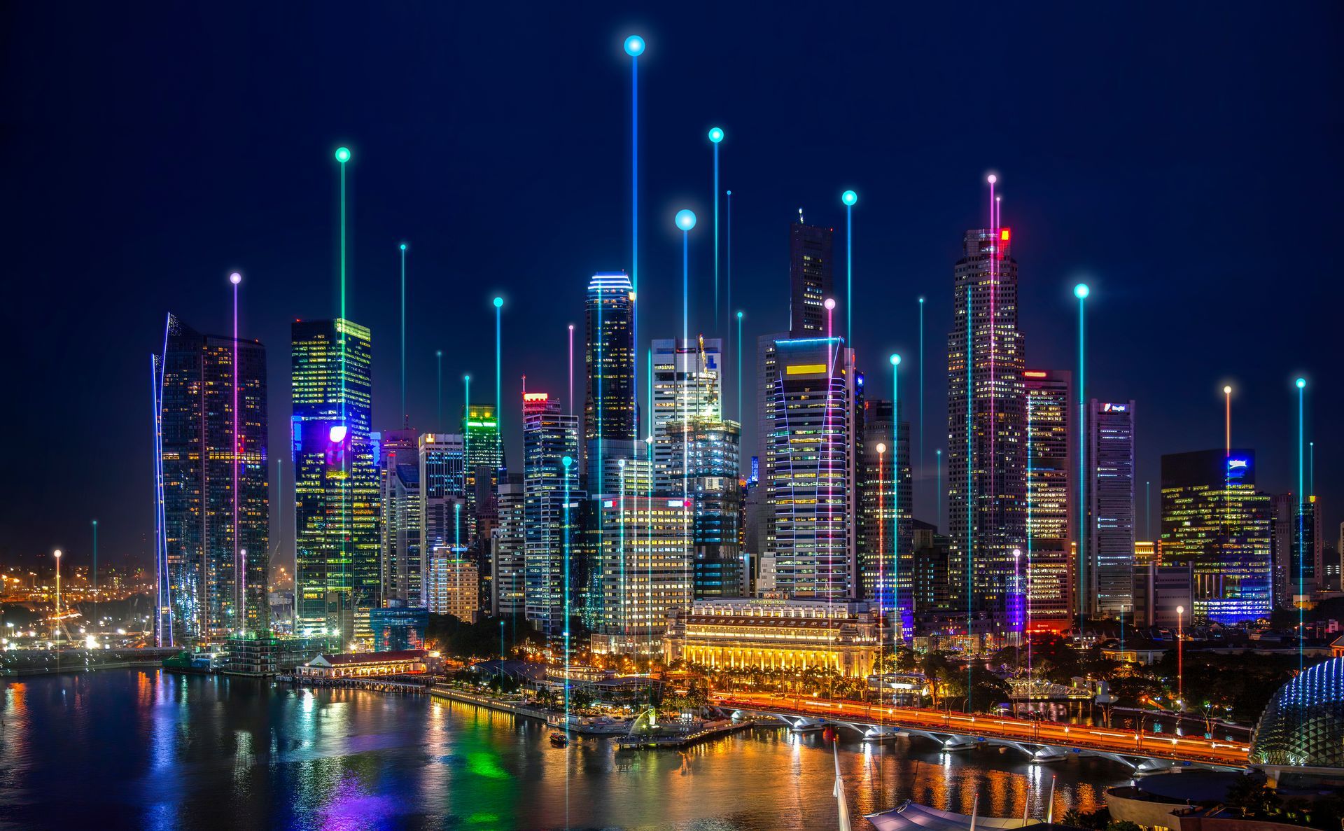 Nighttime cityscape with illuminated skyscrapers, connected by glowing lines, over a body of water.