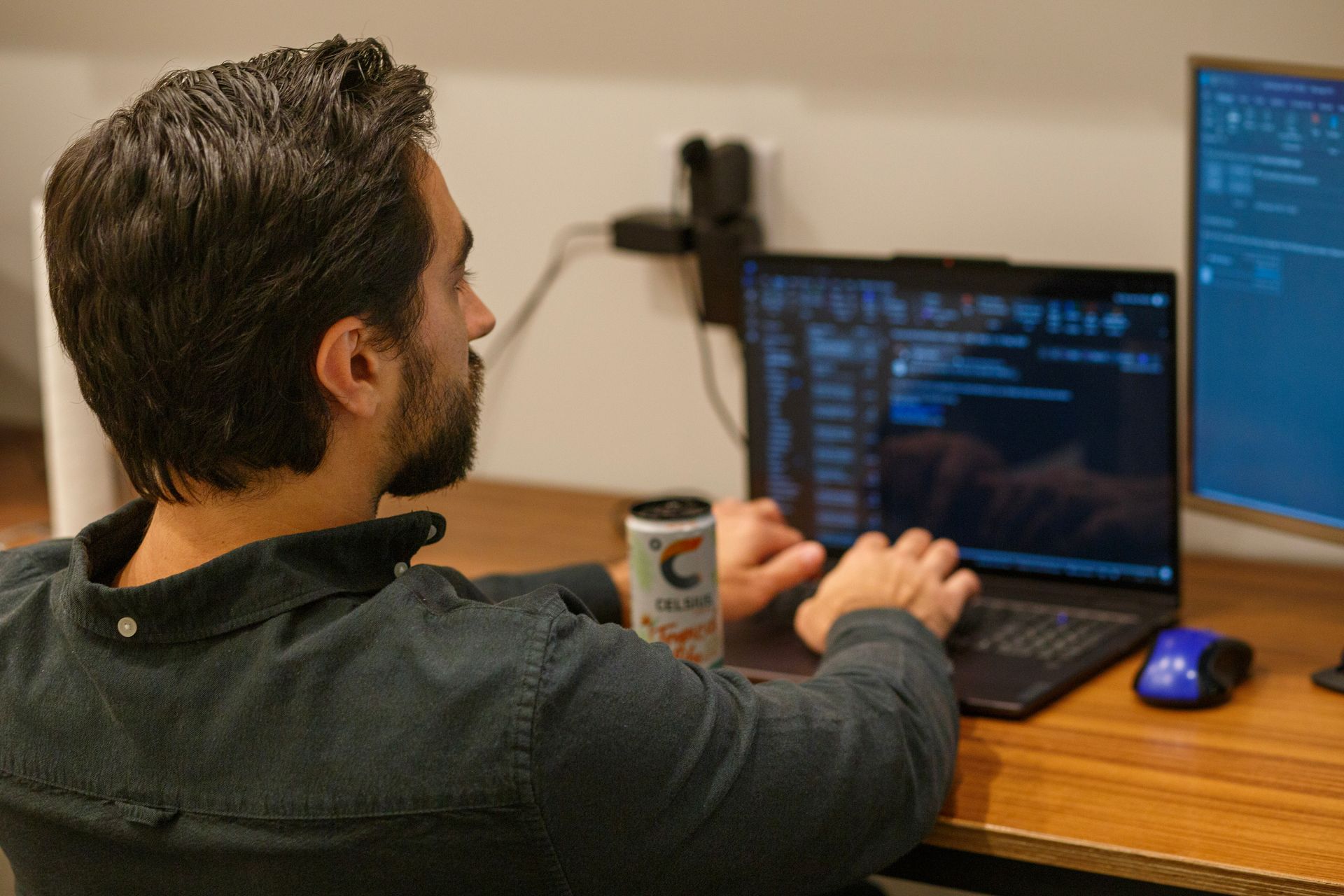 A man is sitting at a desk using a laptop computer.