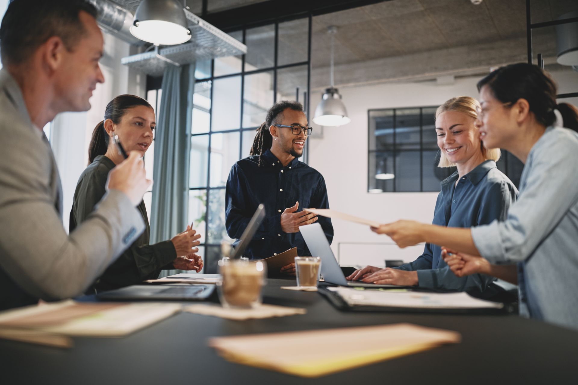A group of people are sitting around a table having a meeting.