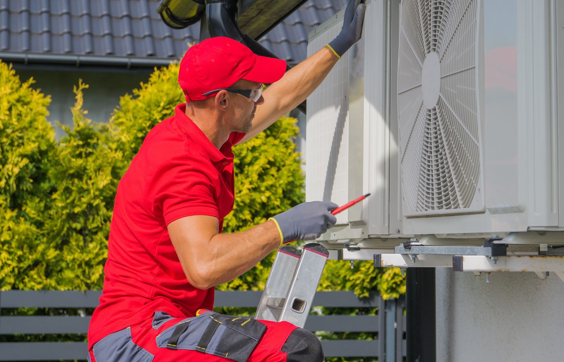 A residential air conditioning maintenance technician at work A residential air conditioning maintenance technician at work