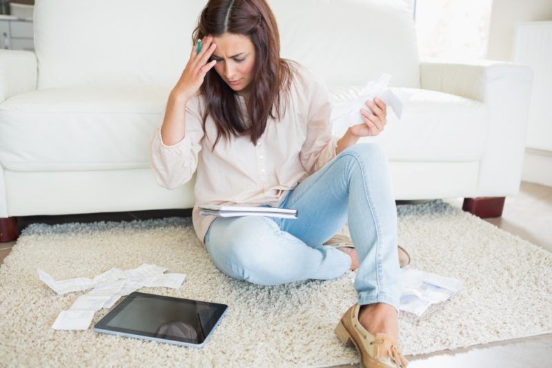 Stressed woman with tablet and papers