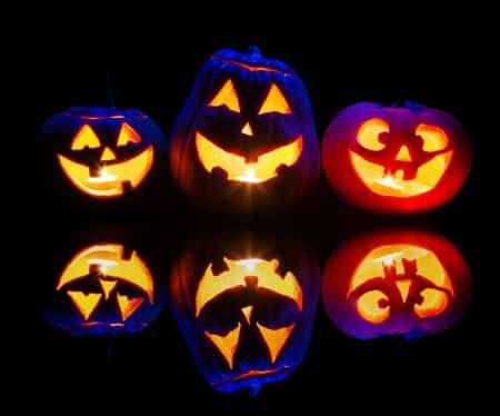 Glowing lanterns with carved faces against a black background Glowing lanterns with carved faces against a black background