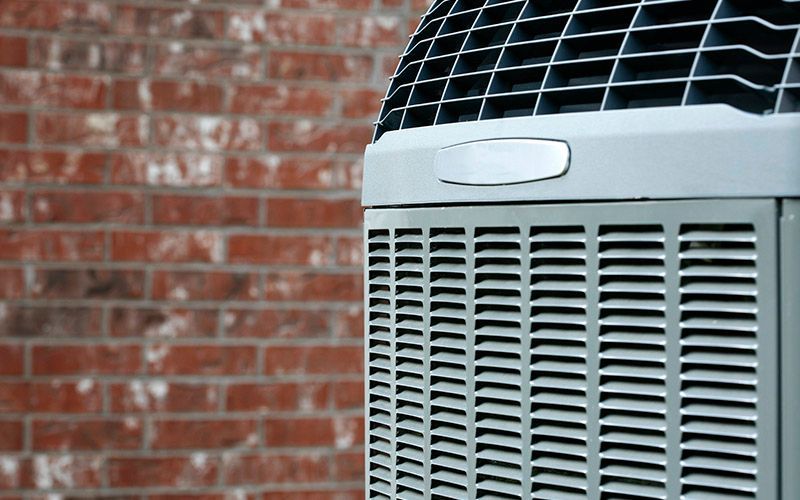 Air conditioner unit against a red brick wall