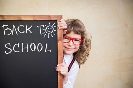 Girl with red glasses peeking from behind a chalkboard Girl with red glasses peeking from behind a chalkboard